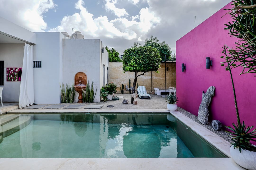 Modern backyard pool with vibrant walls and cozy seating.
