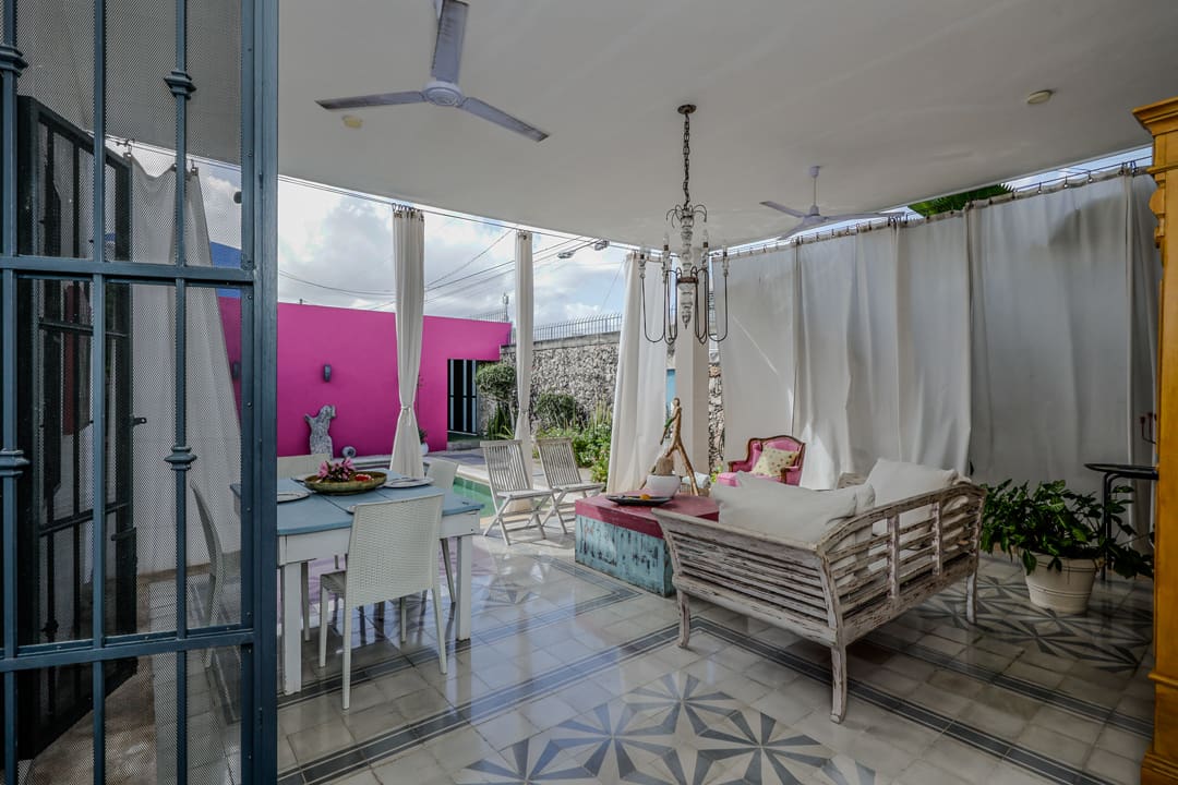 Cozy indoor swing chair with vibrant pink graffiti outside.