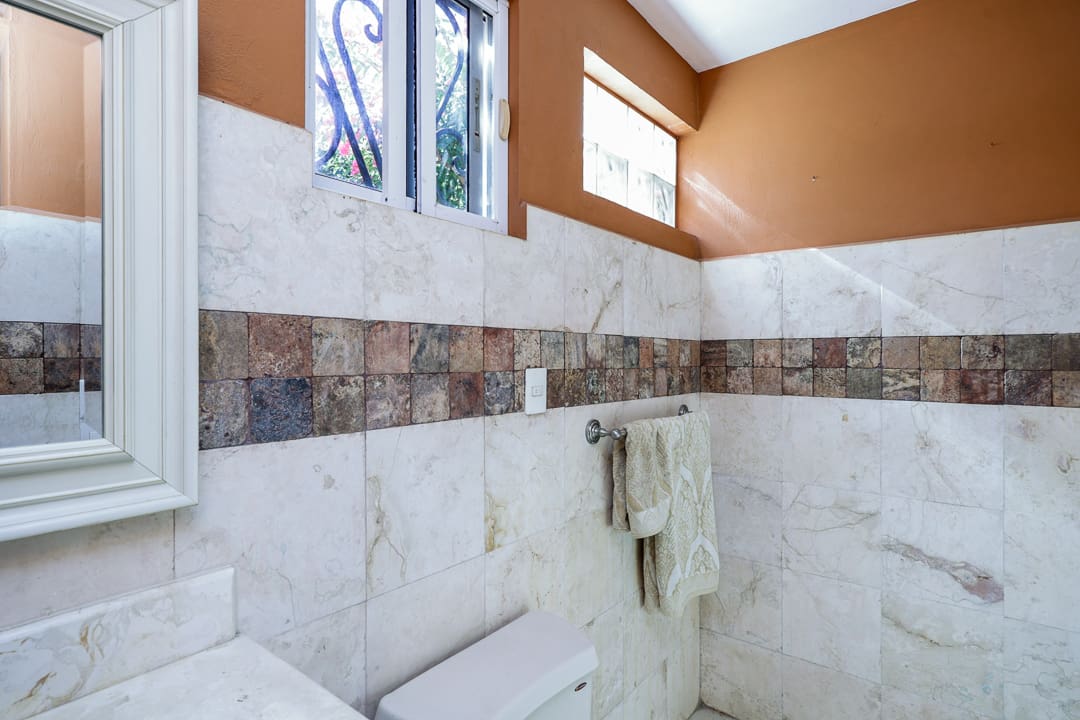 Modern bathroom with marble tiles and a large window.