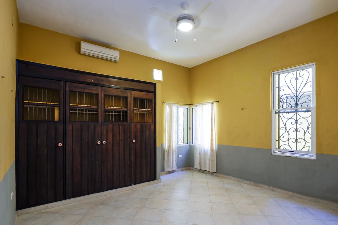 Bright empty room with wooden closets and yellow walls.