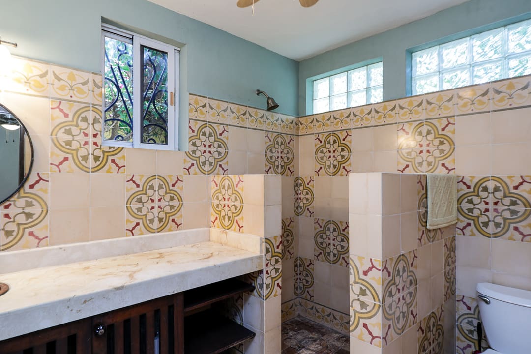 Elegant bathroom with decorative tiled walls and a wooden countertop.