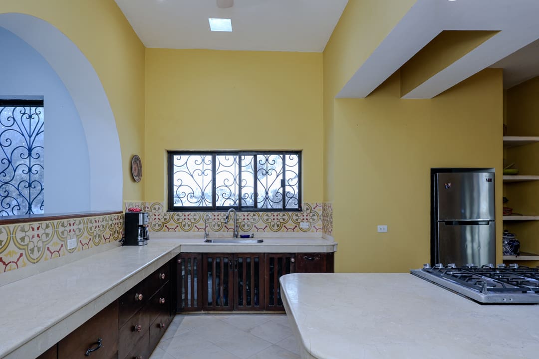Bright kitchen with yellow walls and dark wood cabinets.