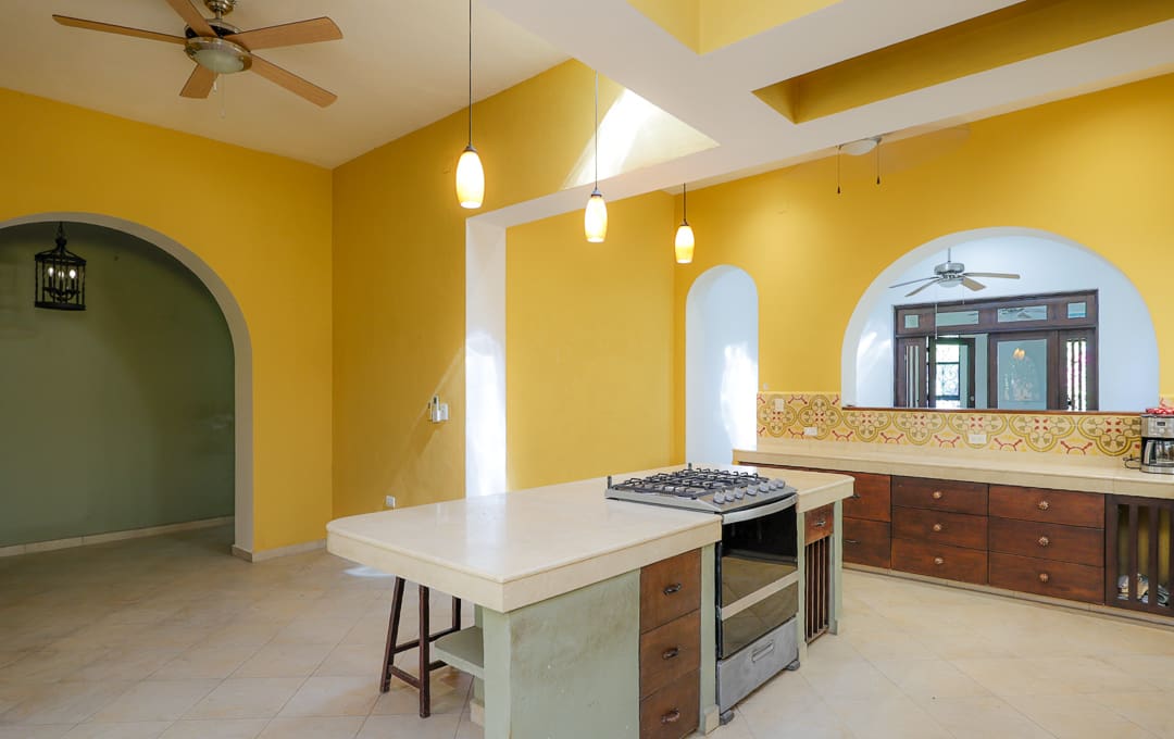 Bright kitchen with yellow walls and a white island countertop.