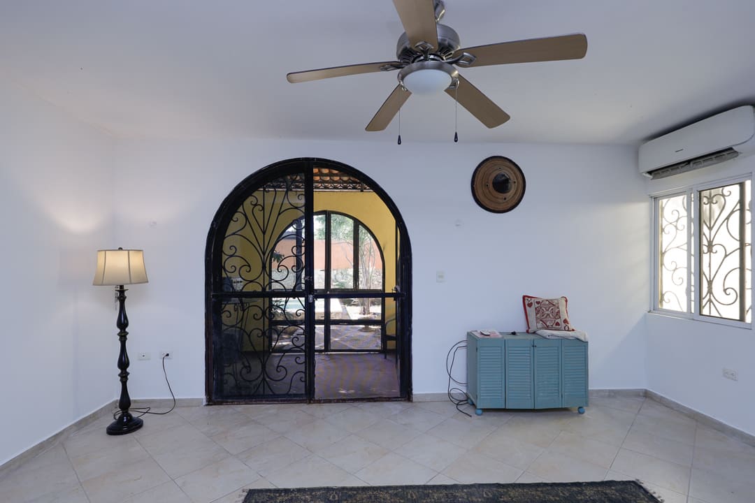 Minimalist room with a ceiling fan and arched glass door.