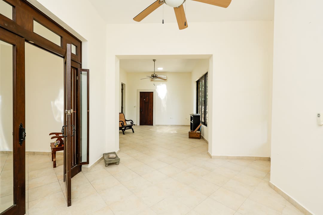 Spacious, empty room with ceiling fans and tiled floor.