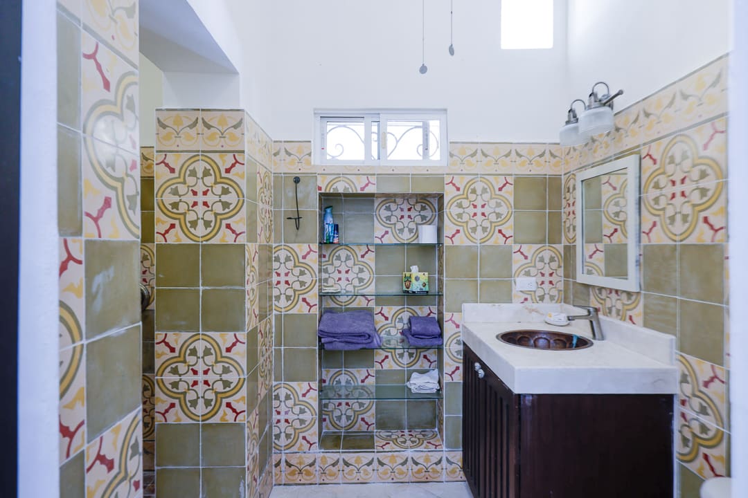 Bathroom with colorful patterned tiles and a dark wood vanity.