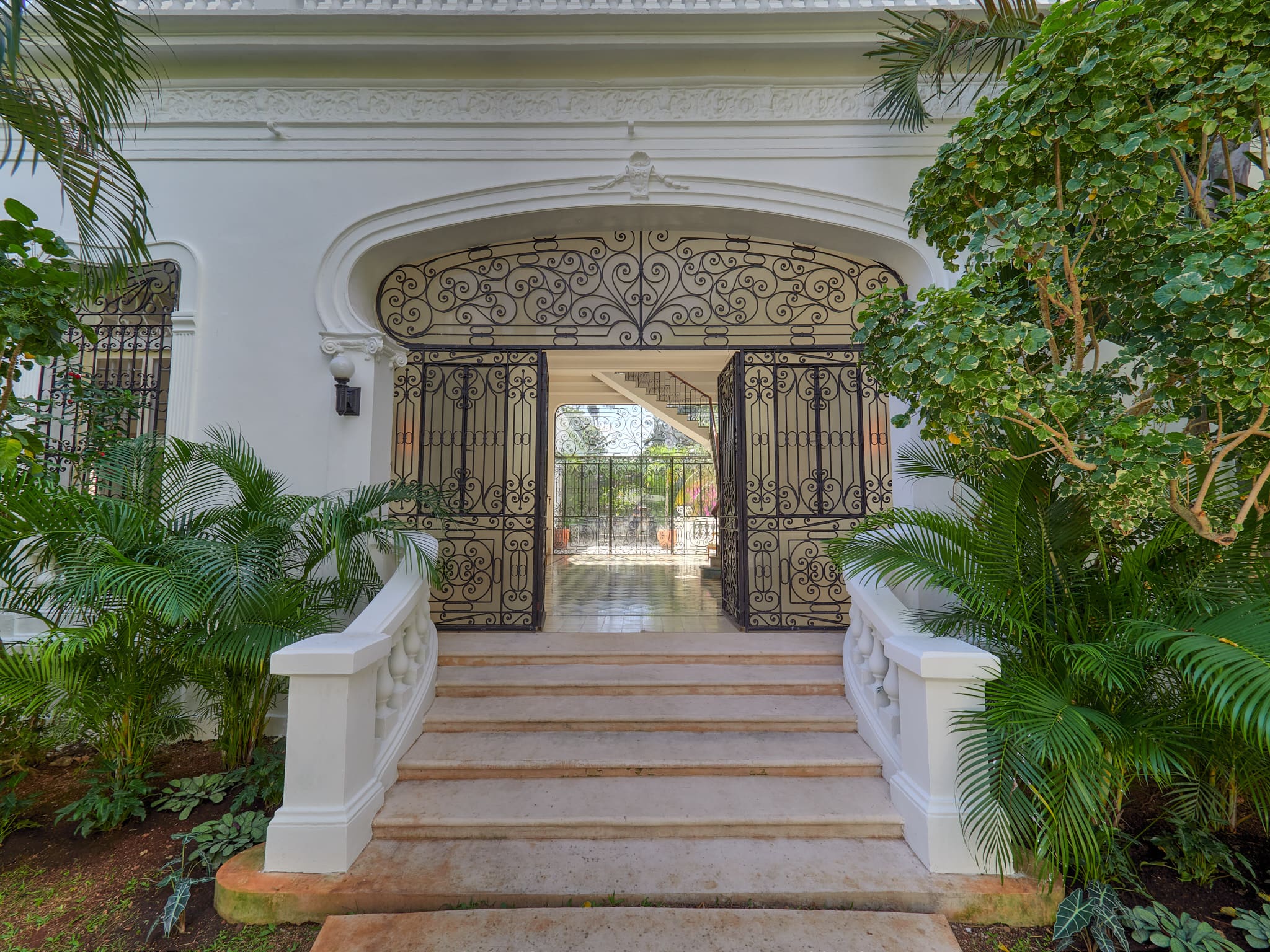 Elegant entrance with ornate iron gates and decorative archway.