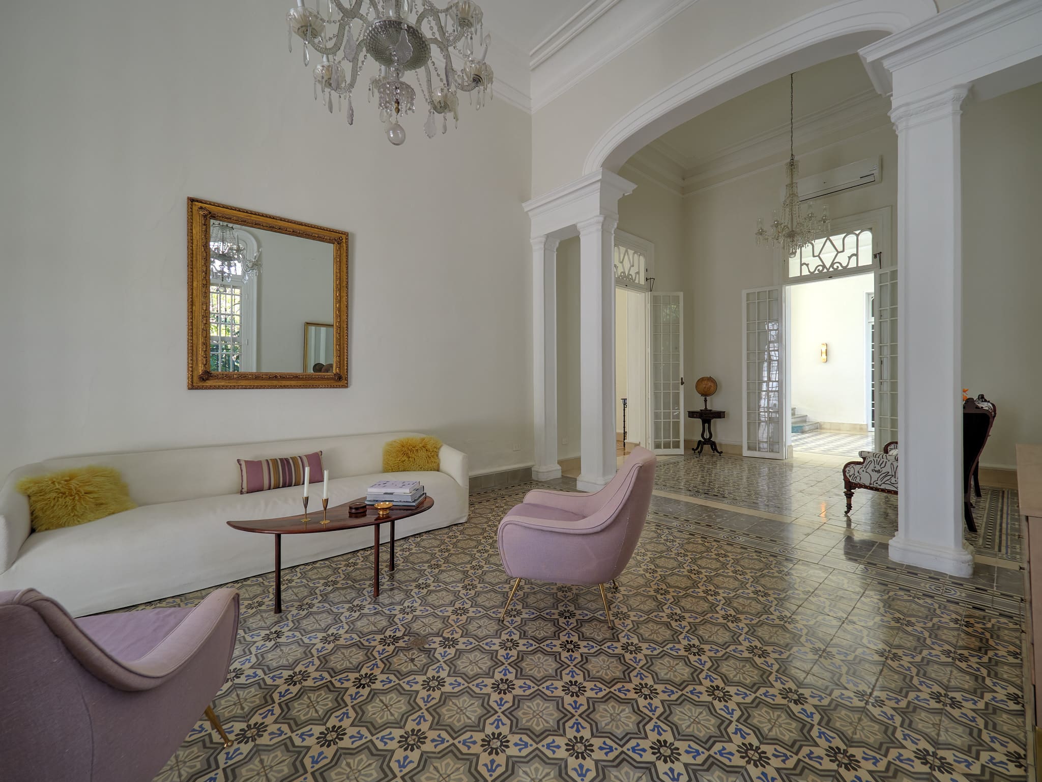 Elegant living room with vintage tiled floor and pastel furniture.