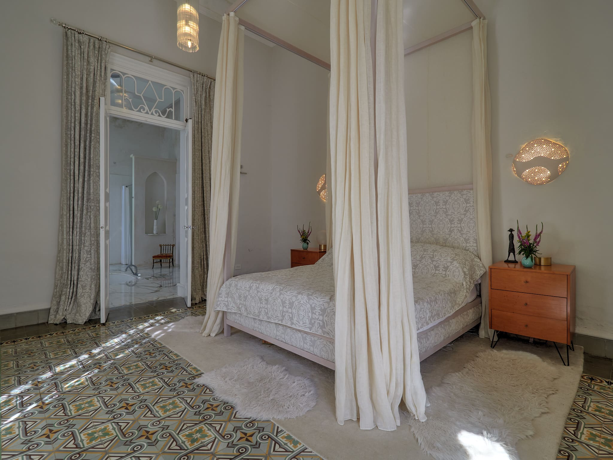 Minimalist bedroom with a canopy bed and rustic door.