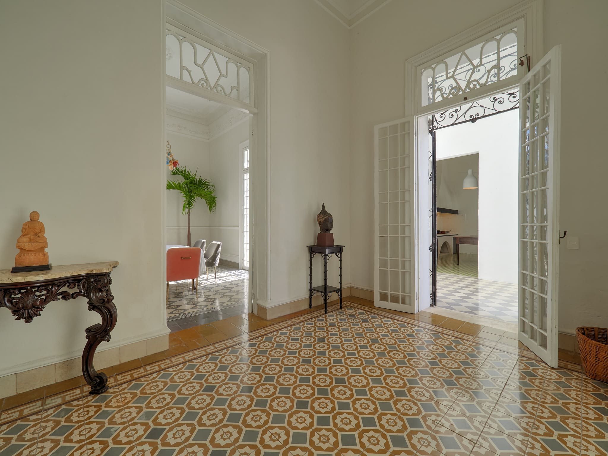 Bright, airy room with patterned tile floor and open doors.