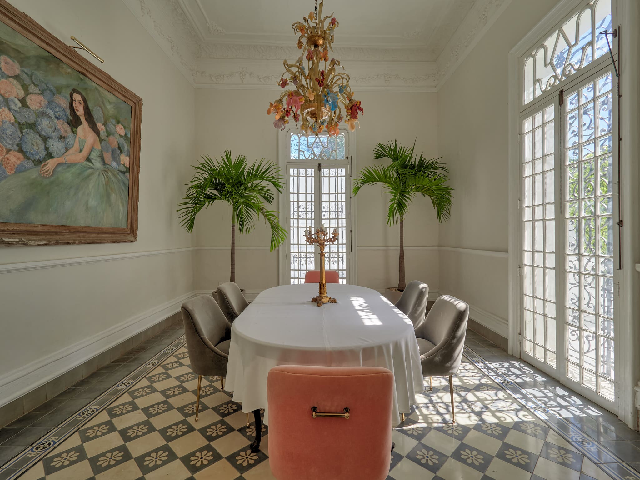 Elegant dining room with chandelier and greenery.