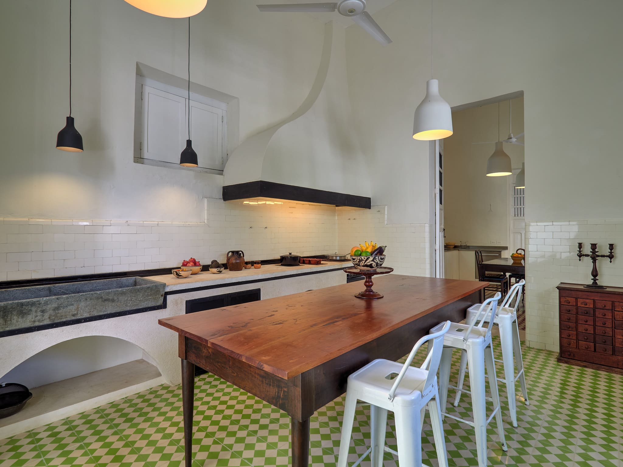 Modern kitchen with wooden table and white chairs.