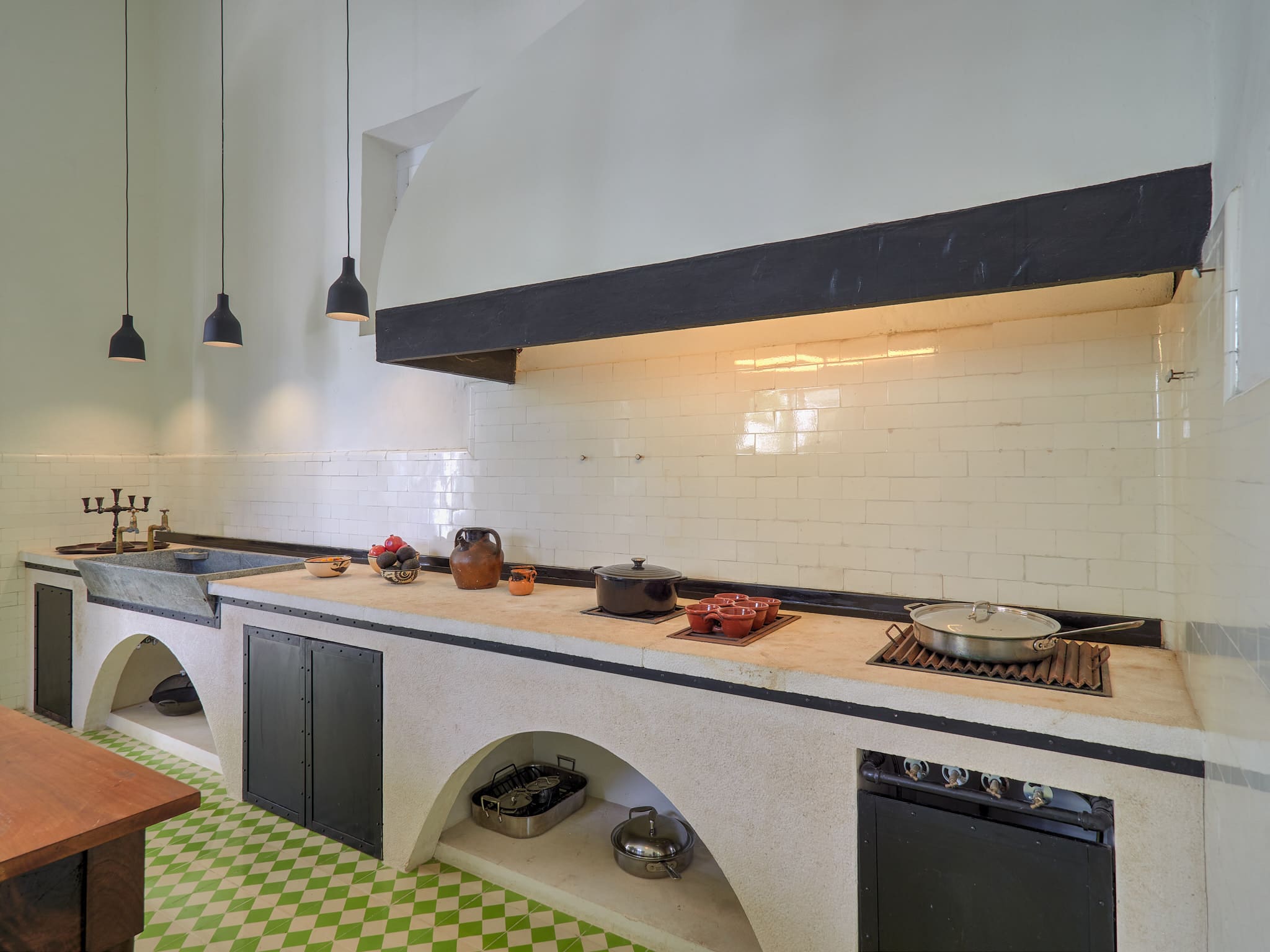 Modern kitchen with clean white tiles and under-counter ovens.