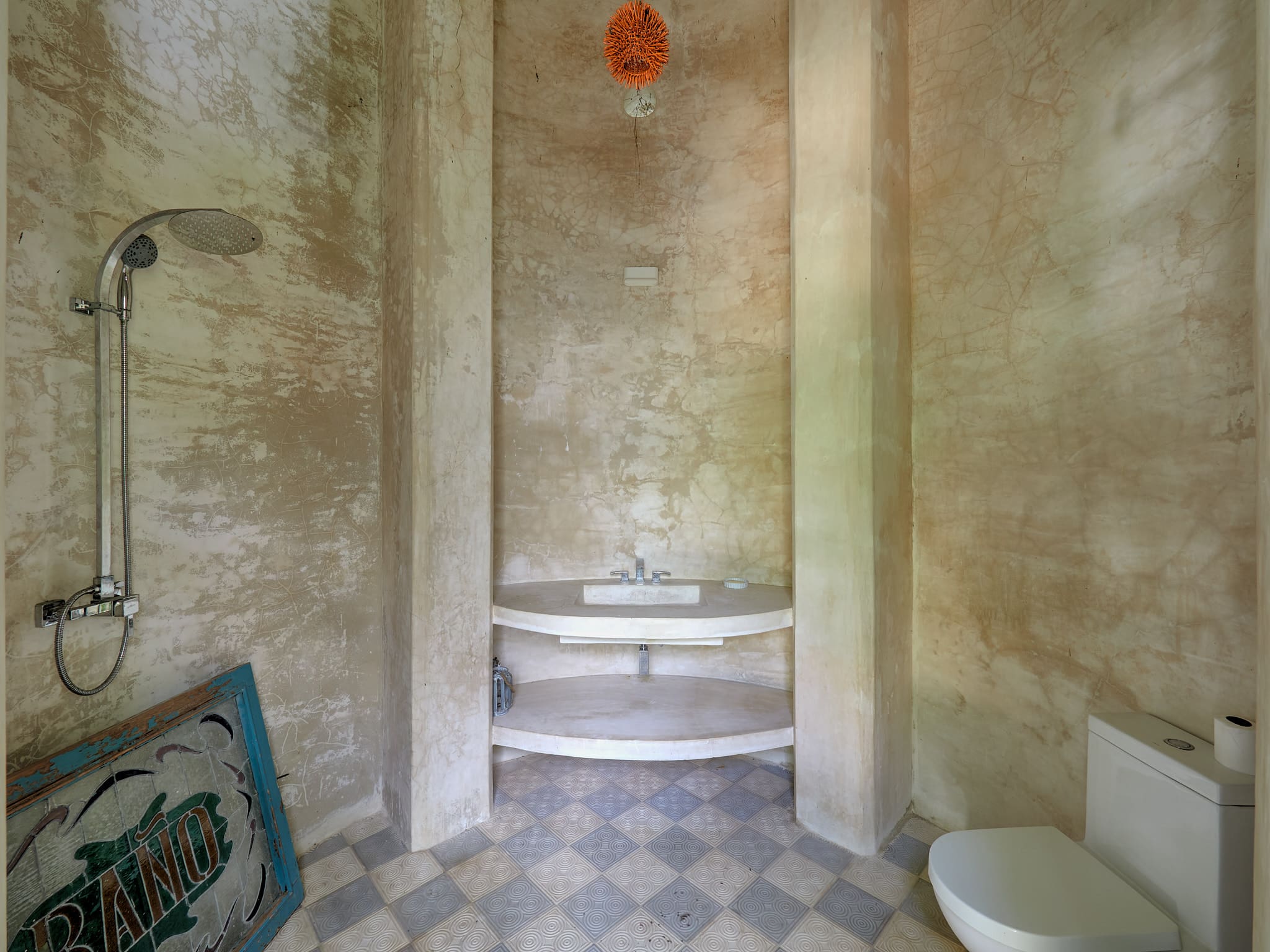 Rustic bathroom with a stone sink and checkered floor tiles.