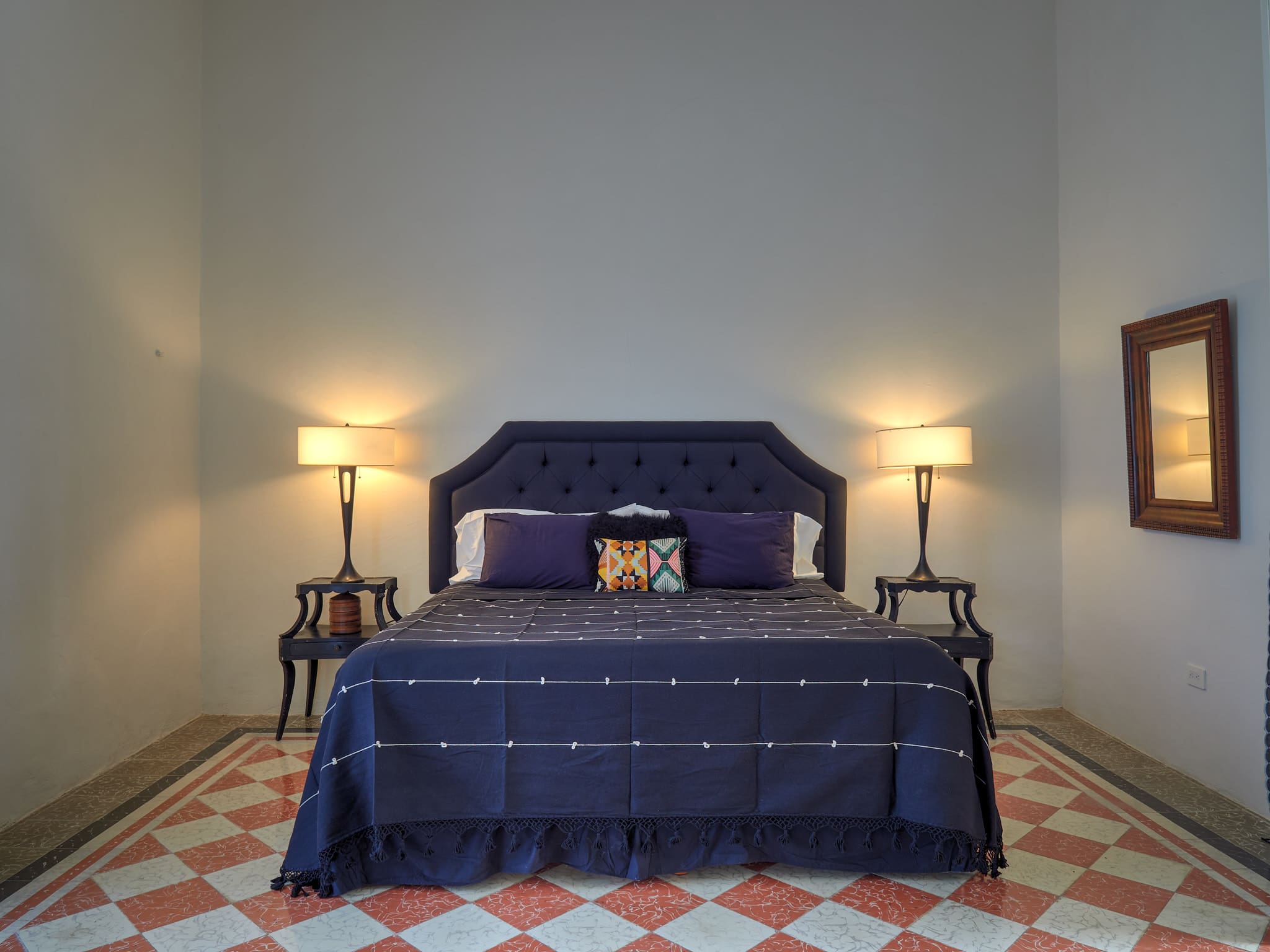 Elegant bedroom with a navy blue tufted headboard and matching bedding.