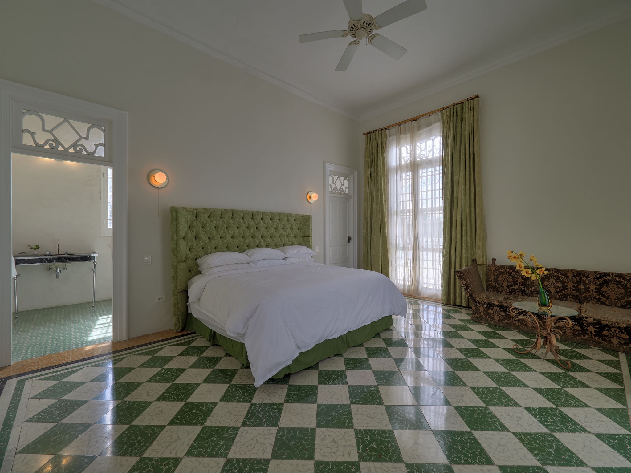 Bright bedroom with green and white checkered floor and large windows.