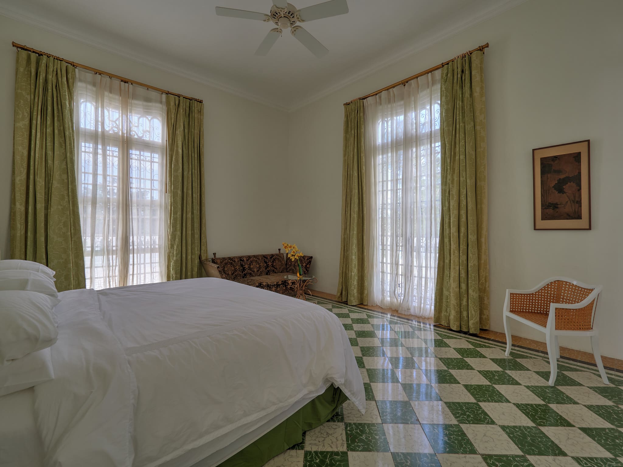Cozy bedroom with large windows and patterned tile floor.