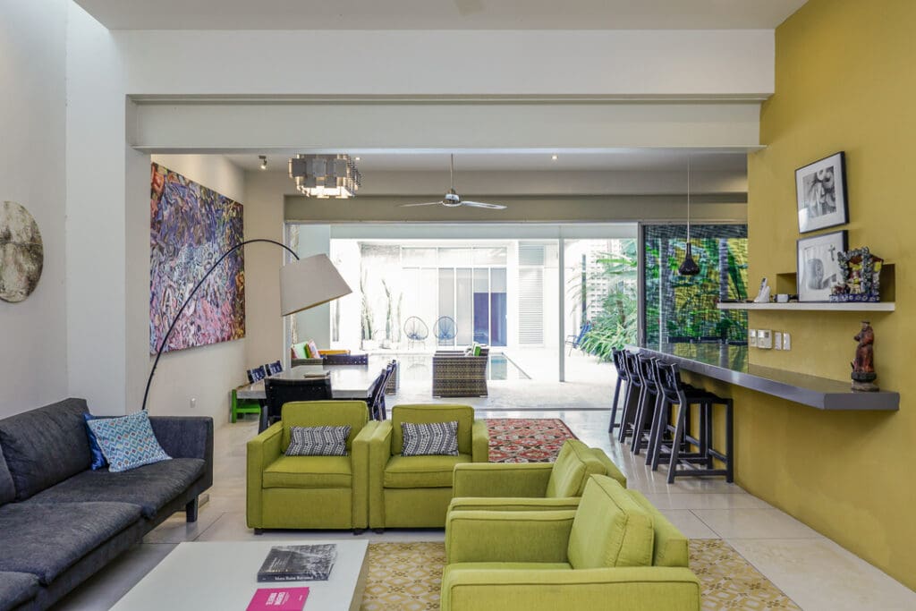 Modern living room with green sofas and natural light.