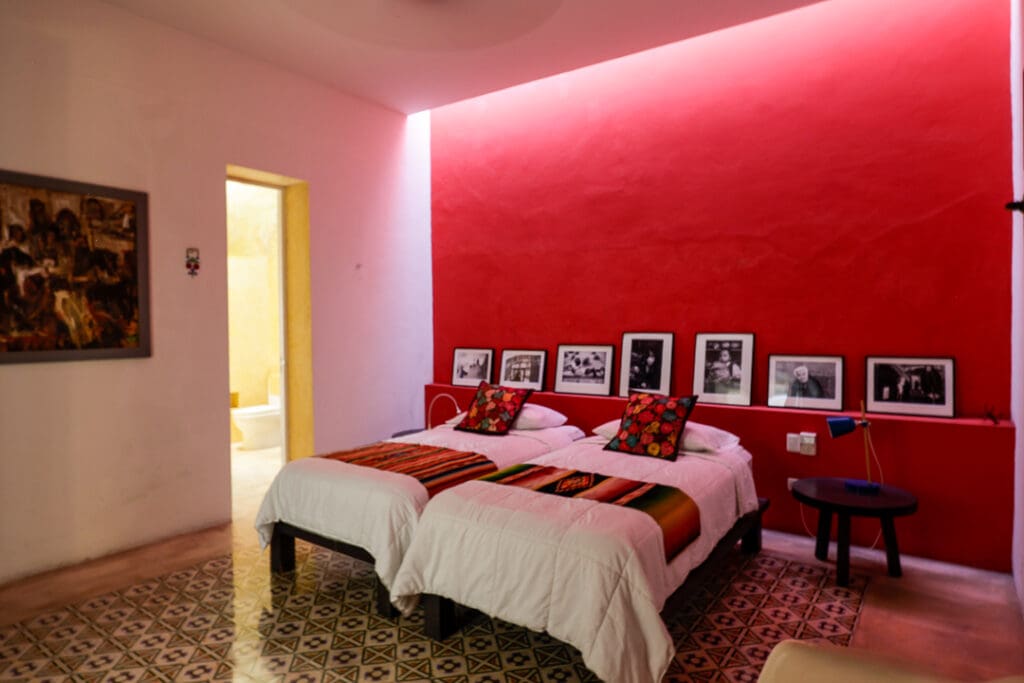 Cozy bedroom with twin beds and vibrant red accent wall.