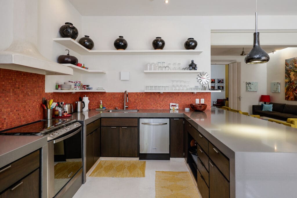Modern kitchen with dark cabinets and red backsplash tiles.