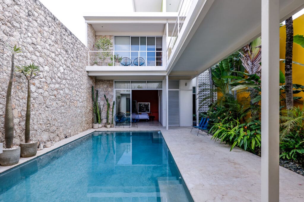 Modern house with a sleek pool and stone walls.