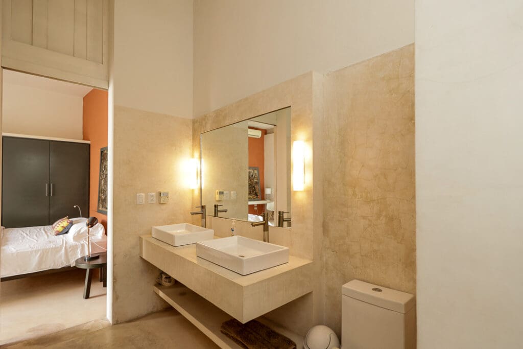 Modern bathroom with double sinks and warm lighting.