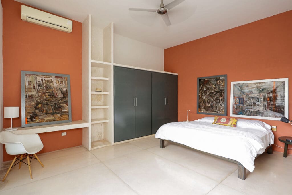 Minimalist bedroom with orange accent wall and built-in chalkboard.