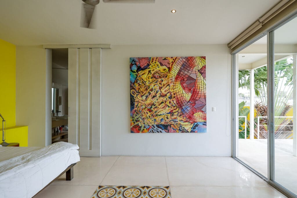 Bright abstract painting in a minimalist white room with large windows.