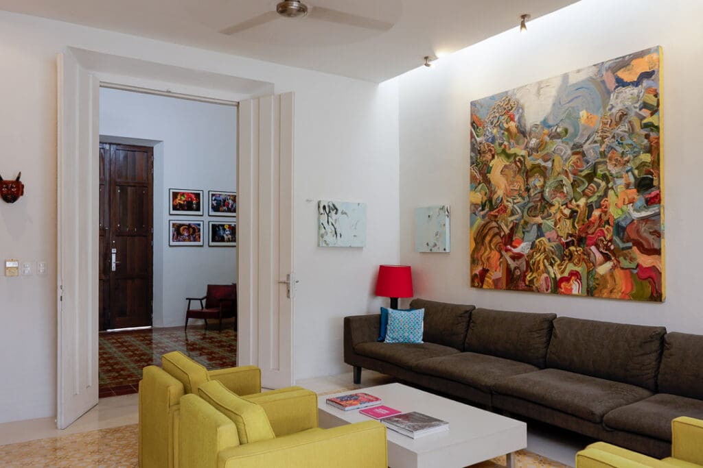 Modern living room with colorful seating and vibrant artwork.