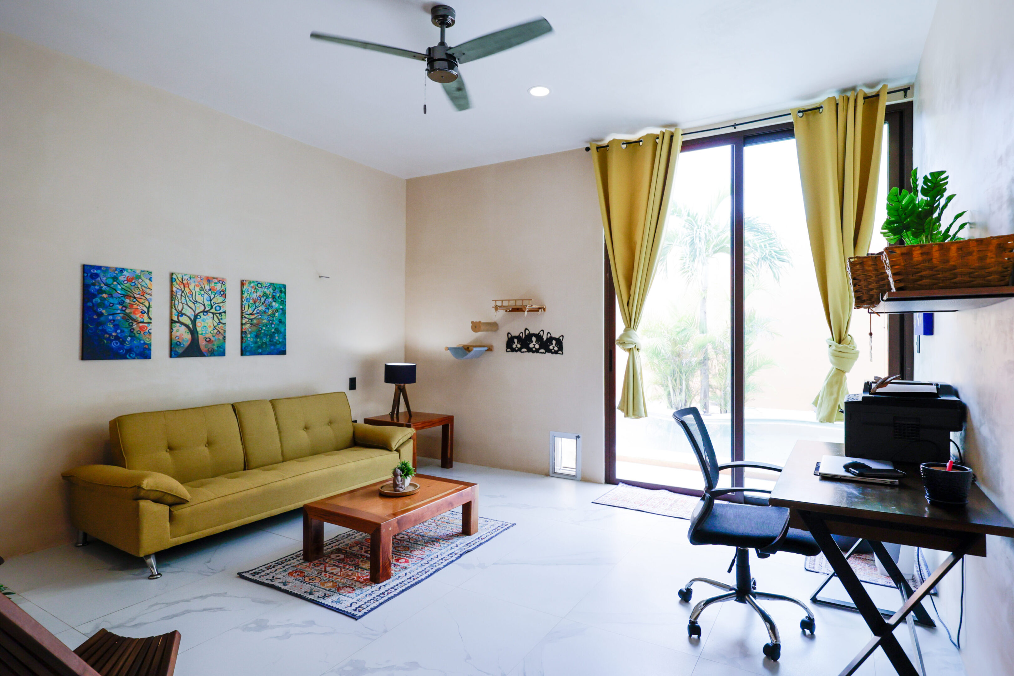 Bright living room with yellow sofa and large window.