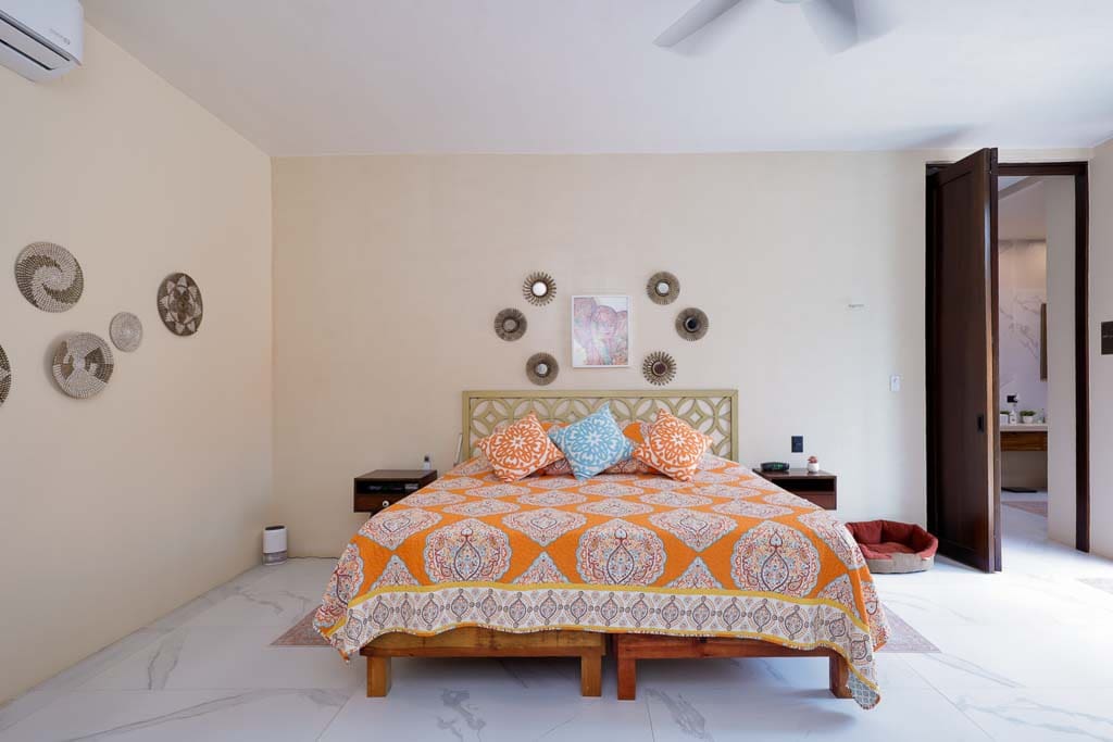 Cozy bedroom with patterned bedding and decorative wall clocks.