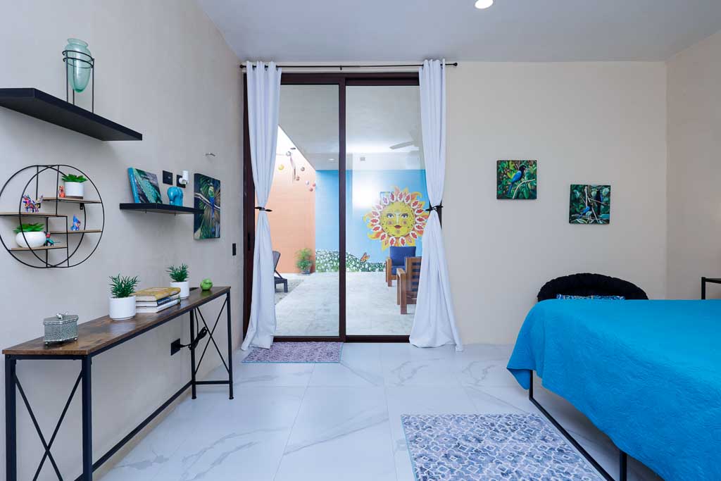 Bright, modern bedroom with blue accents and large window.
