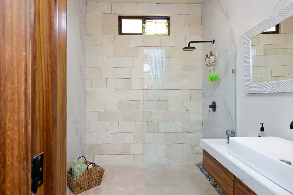 Minimalist bathroom with a tiled shower and wooden accents.