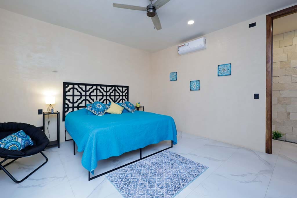 Modern bedroom with blue bedding and minimalist decor.