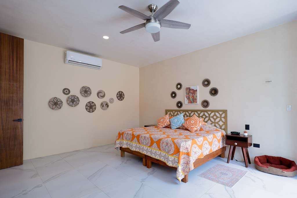 Cozy bedroom with a patterned bedspread and decorative wall art.
