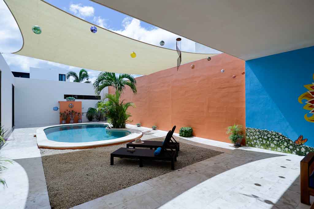 Cozy outdoor pool area with lounge chairs and a palm tree.