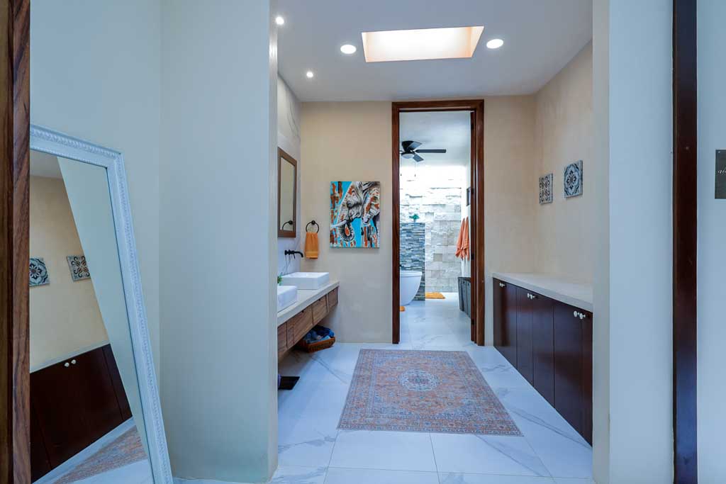 Modern bathroom with skylight and open door to outdoor area.