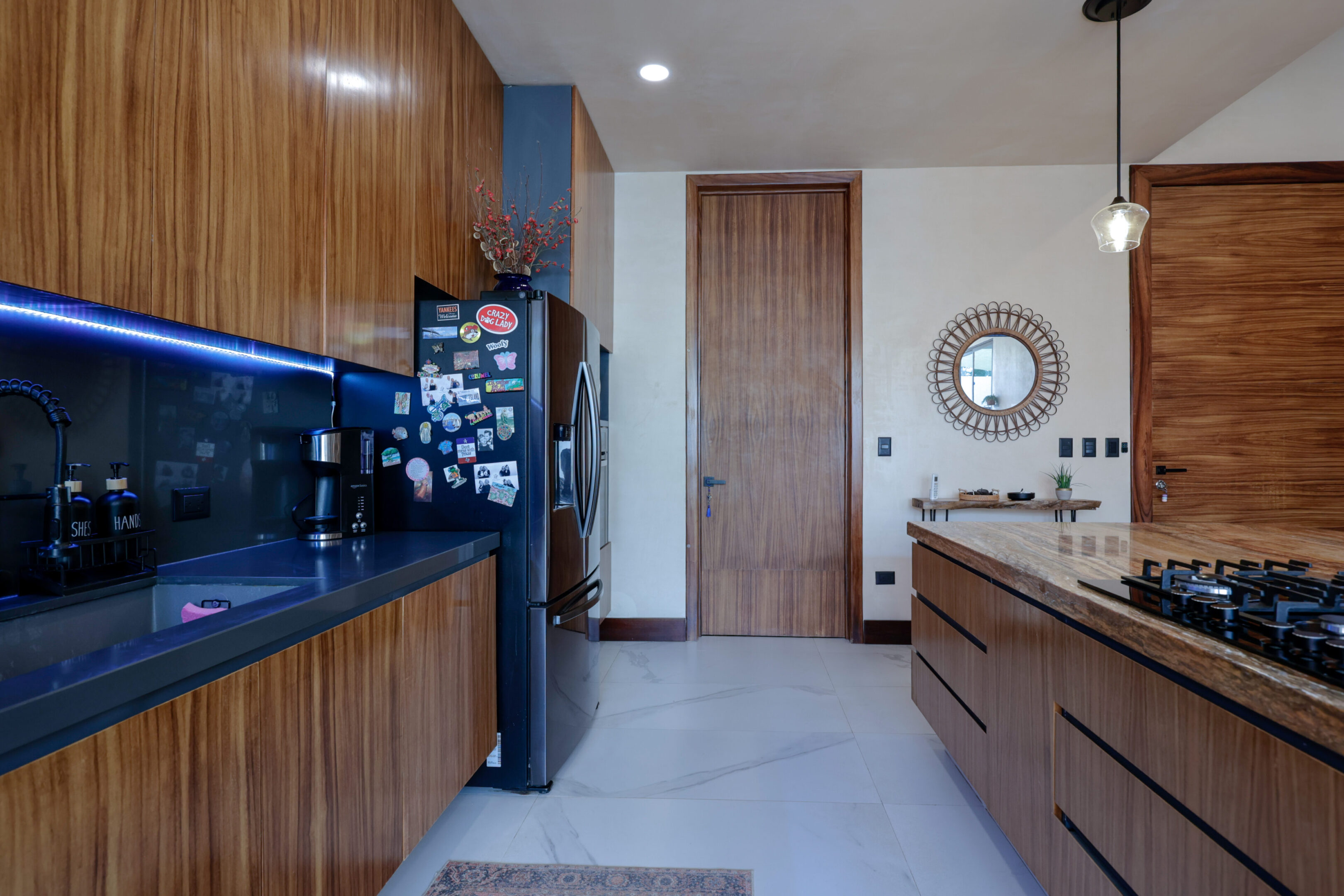 Modern kitchen with wood cabinetry and sleek black appliances.