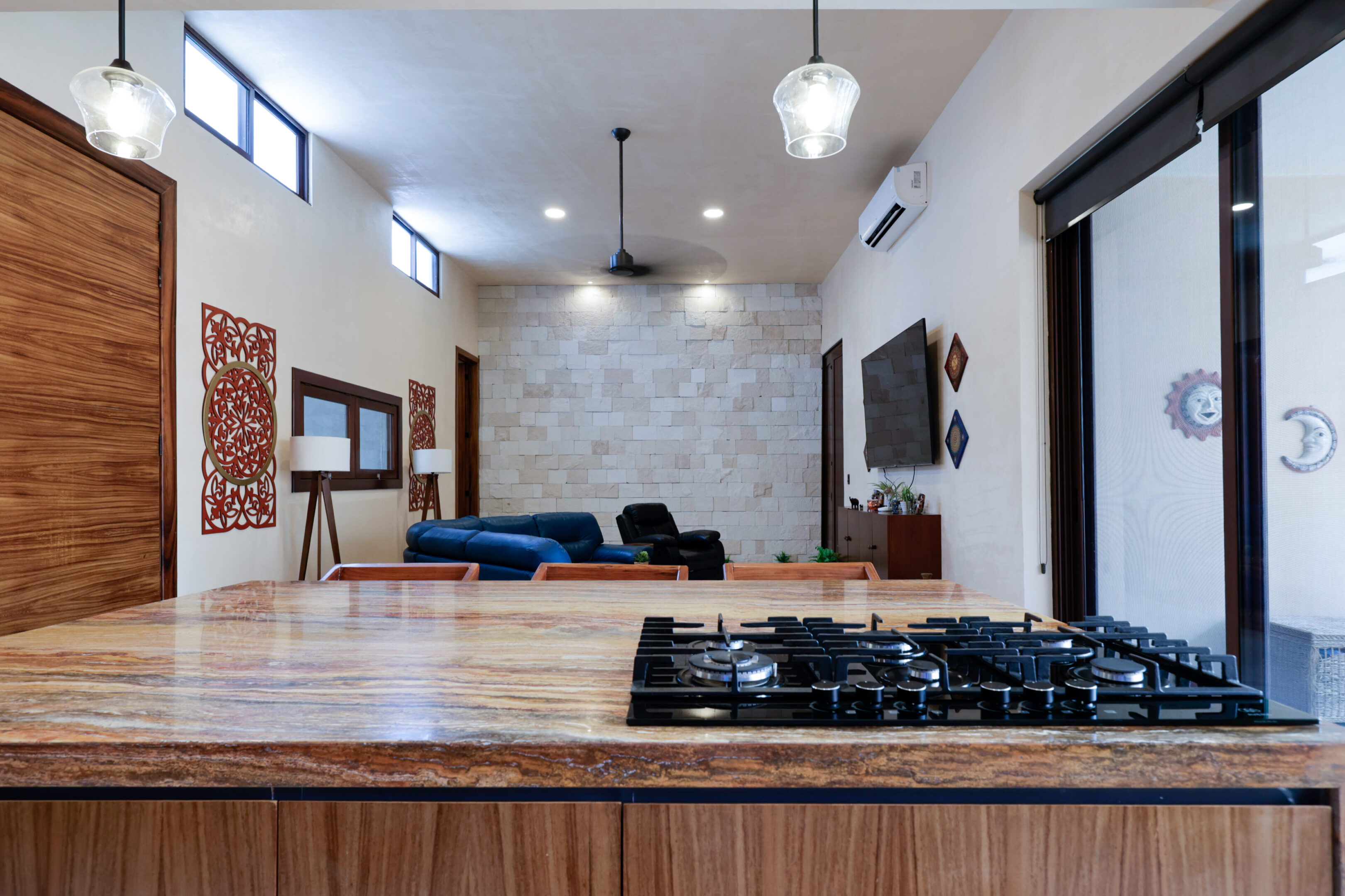 Modern kitchen with wooden countertops and cozy living area in the background.