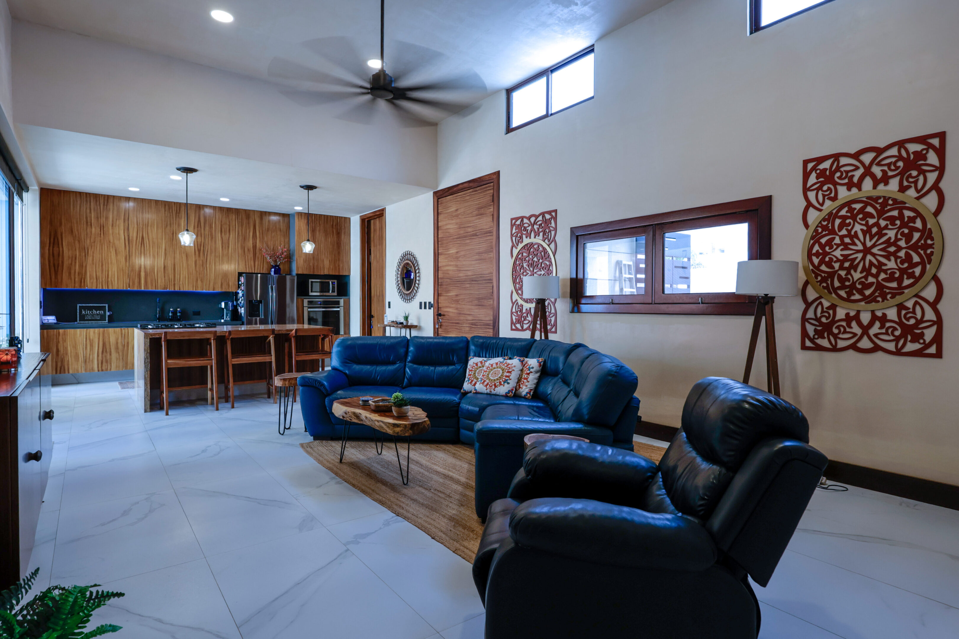 Modern living room with a blue sectional sofa and black recliner.
