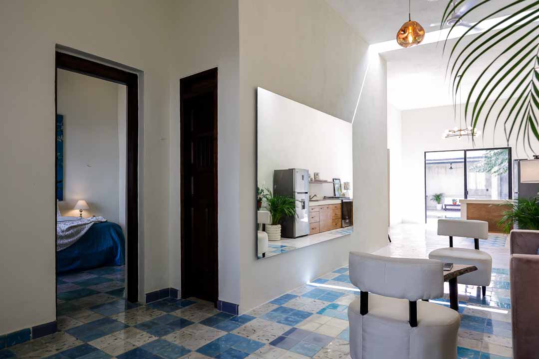 A modern dining area with a wall-mounted TV and checkered floor tiles.