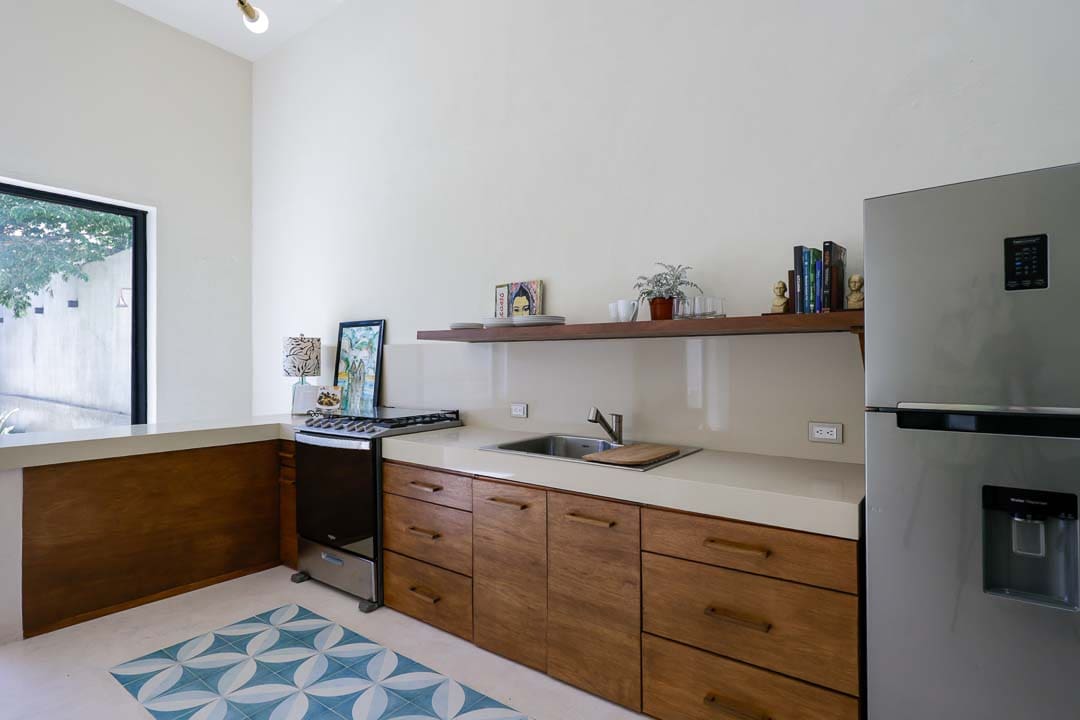 Modern kitchen with wooden cabinets and floating shelves.