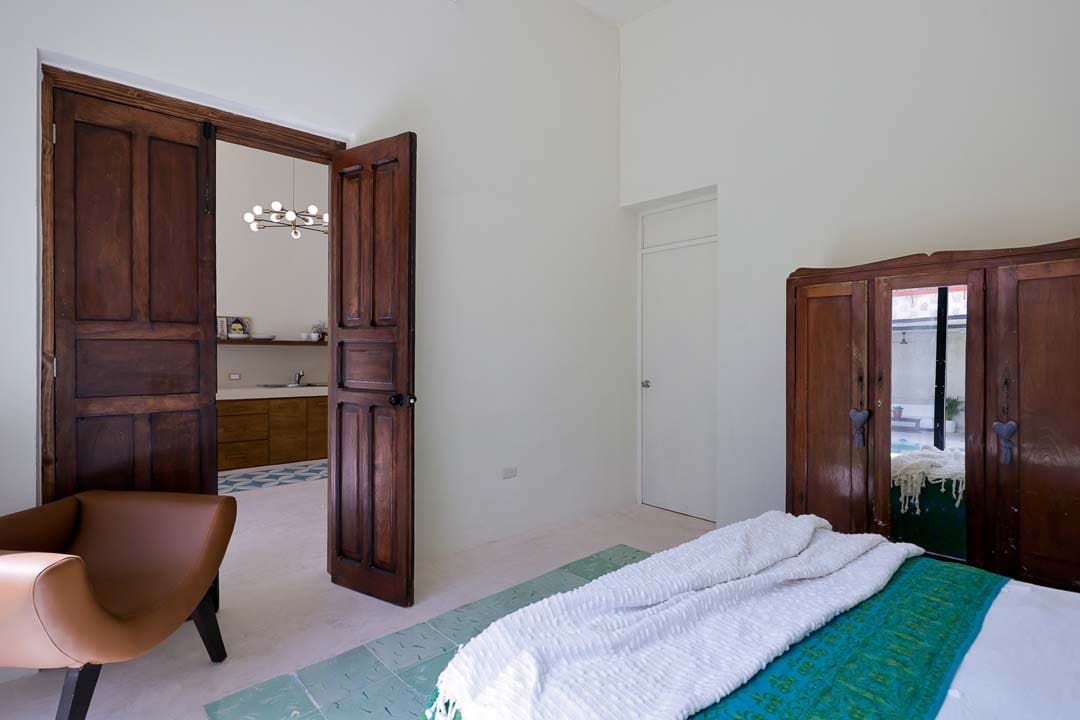 Simple bedroom with wooden door and a neatly made bed.