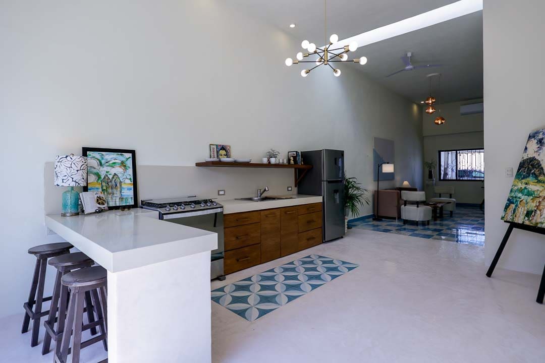 Modern kitchen with wooden cabinets and a geometric rug.