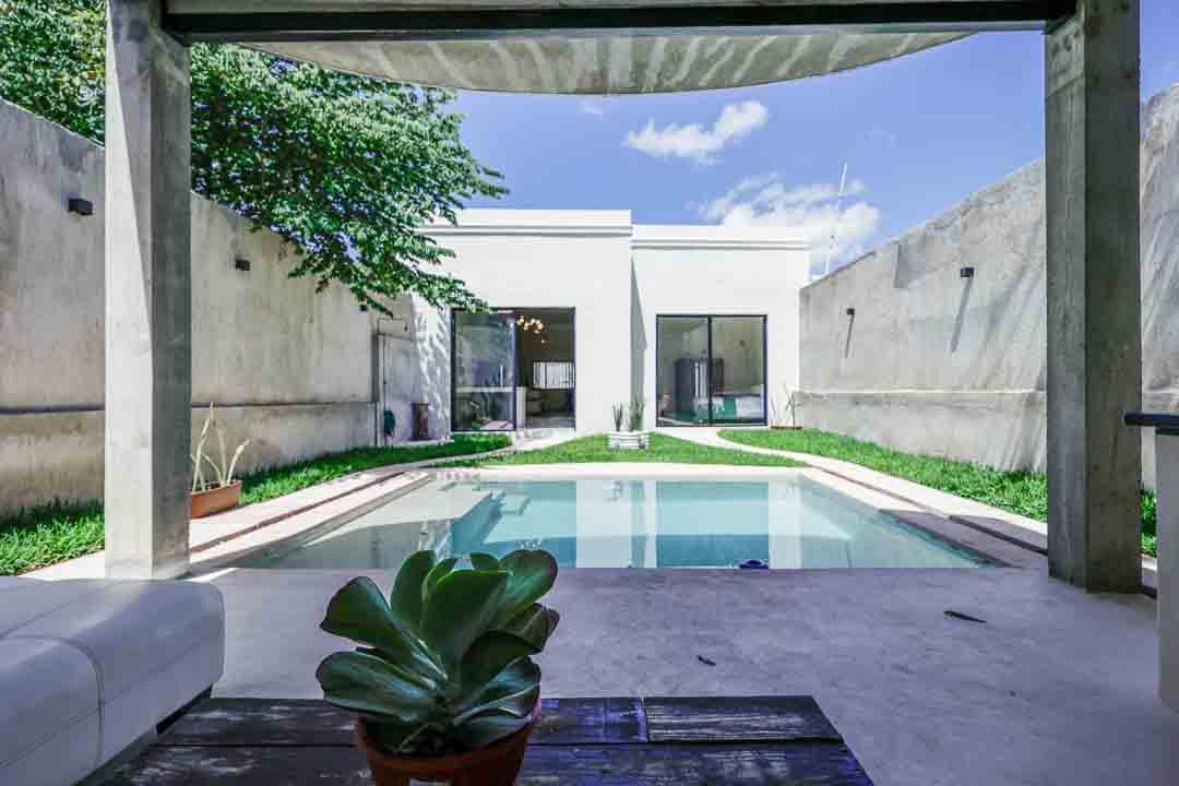 Modern backyard with a pool and minimalist design under a clear sky.