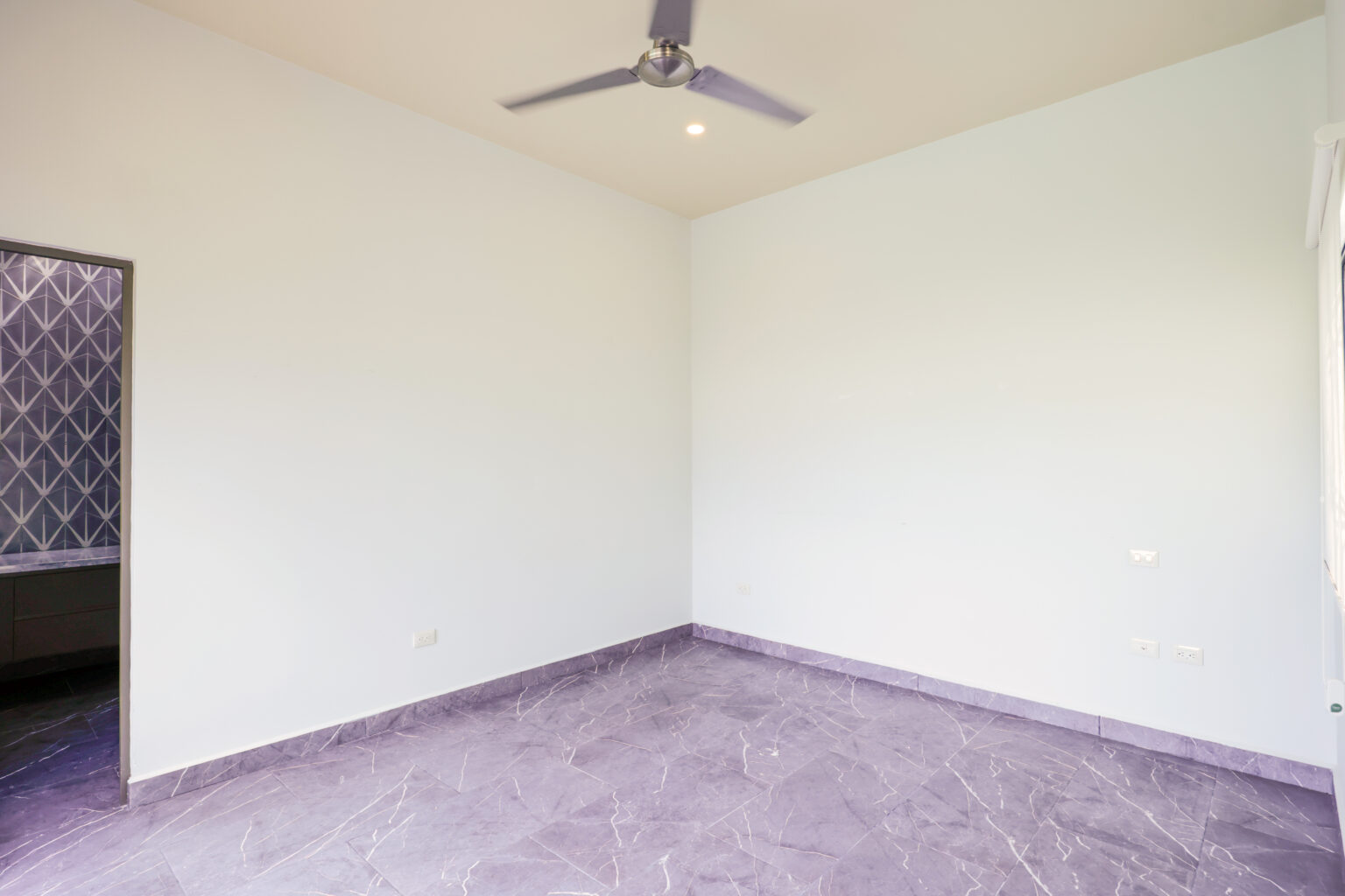 Empty room with white walls and ceiling fan.