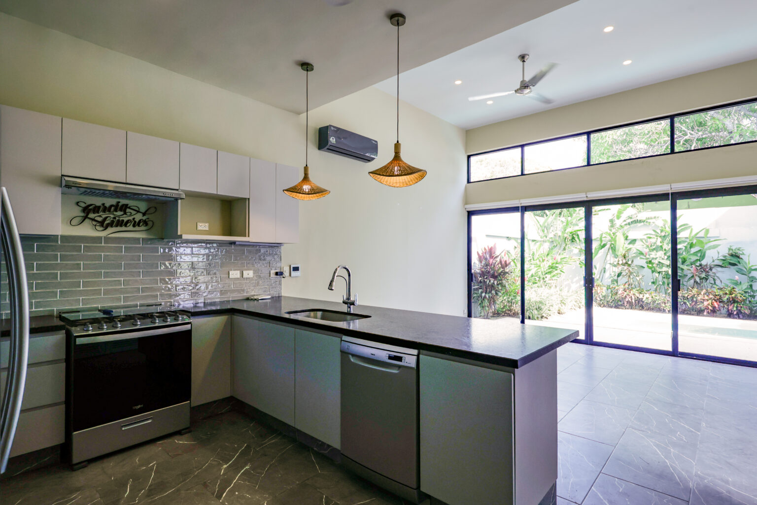 Modern kitchen with sleek appliances and large windows.