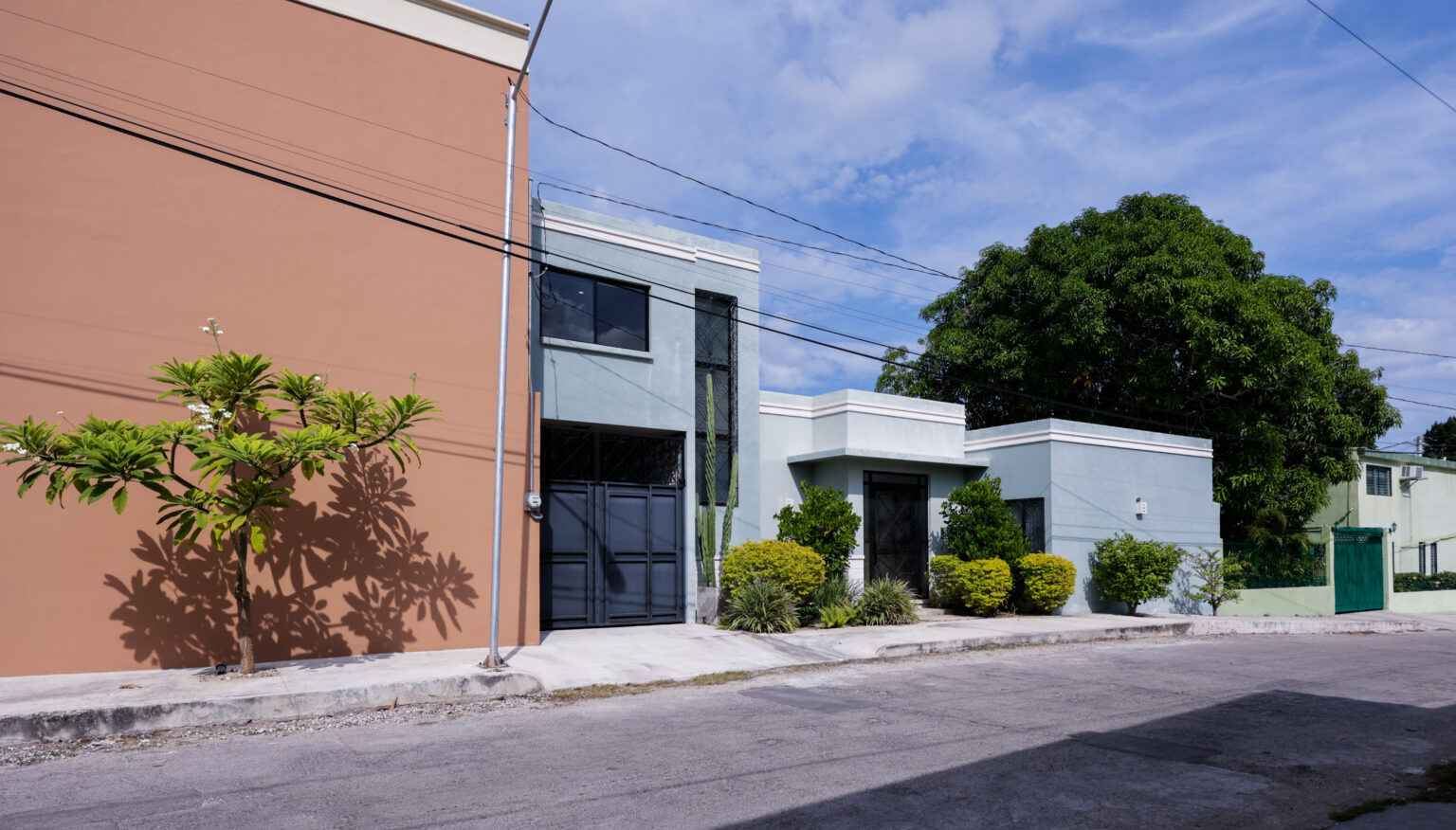 Modern residential buildings with clean lines and greenery on a sunny day.