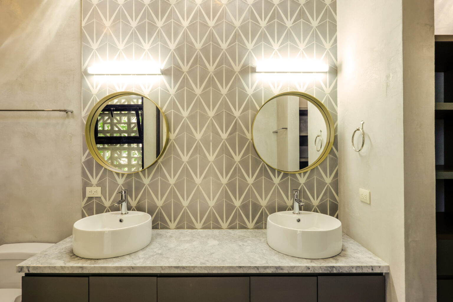 Modern bathroom with twin round mirrors and vessel sinks.