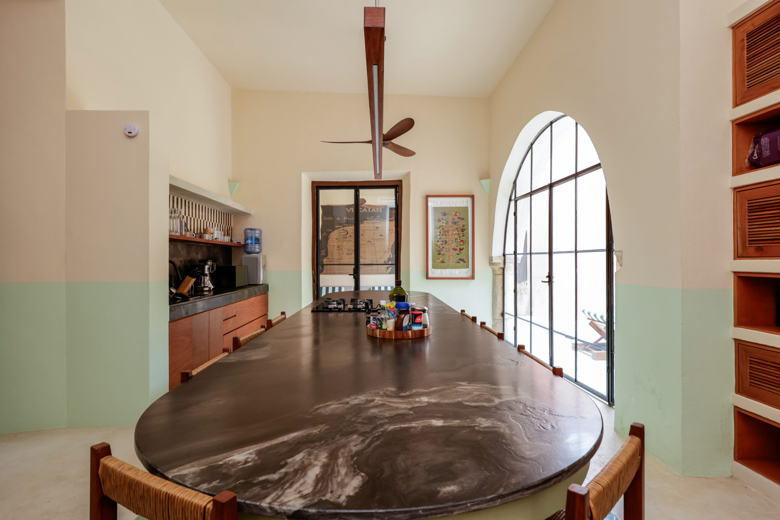 Elegant dining room with a large wooden table and modern ceiling fan.